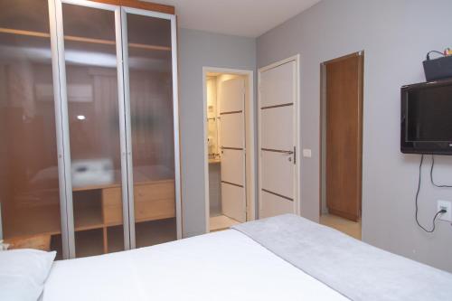 a bedroom with a white bed and a television at Lobie Queen Ipanema in Rio de Janeiro