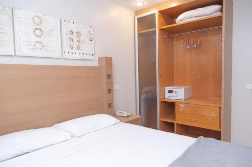 a bedroom with a white bed and a wooden cabinet at Lobie Queen Ipanema in Rio de Janeiro