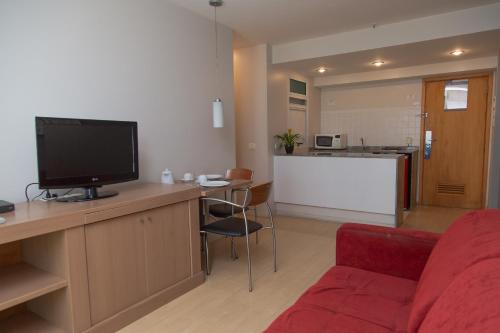 a living room with a red couch and a flat screen tv at Lobie Queen Ipanema in Rio de Janeiro