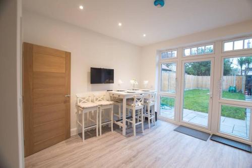 a room with a desk with chairs and a television at New stylish 4 bed house moments from Clacton beach in Clacton-on-Sea