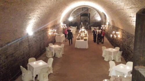 a room with white tables and white chairs in a tunnel at Hotel Torre di San Martino in Gazzola Di Rivalta