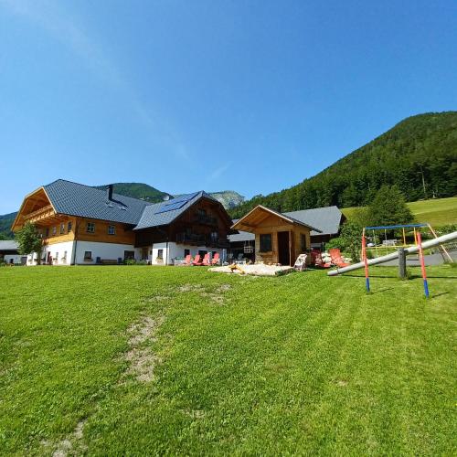 a house with a playground in front of a grass field at Auerhiasbauer in St. Wolfgang