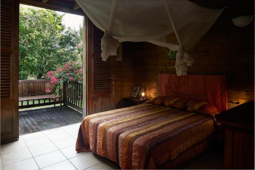 a bedroom with a bed and a sliding glass door at Villa Diodon in Deshaies