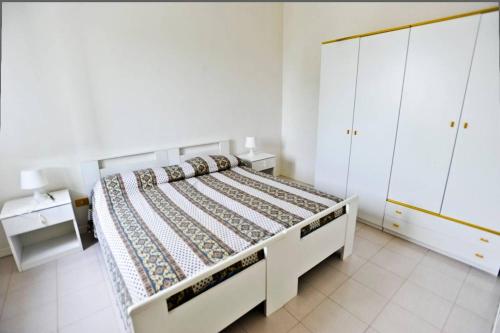 um quarto branco com uma cama e armários brancos em Puglia Villa Mare Gargano Manfredonia em Zapponeta