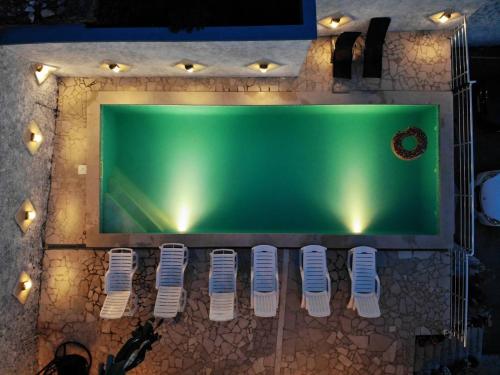 una vista aérea de una mesa verde con sillas blancas en Apartments Horizont Mostar, en Mostar