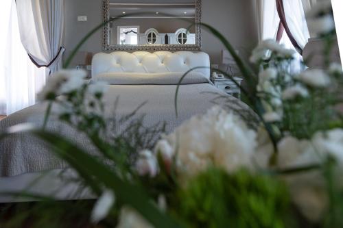 a bedroom with a bed with flowers in front of a mirror at Hotel 1908 in Forte dei Marmi