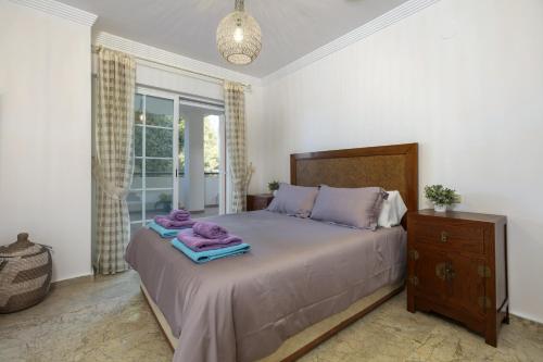 Un dormitorio con una cama con toallas moradas. en Balcon de Puente Romano, en Marbella