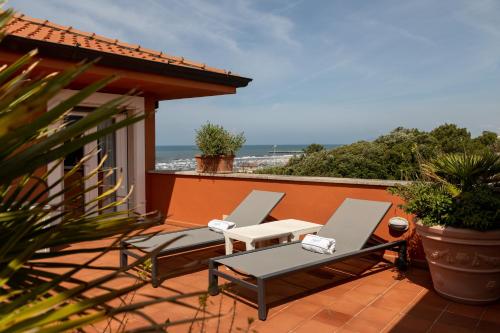 two chairs and a table on a balcony with the ocean at Hotel 1908 in Forte dei Marmi