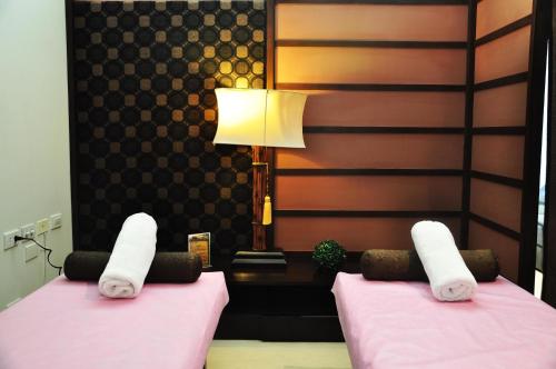two beds in a room with towels on them at Kamana Sanctuary Resort & Spa in Olongapo