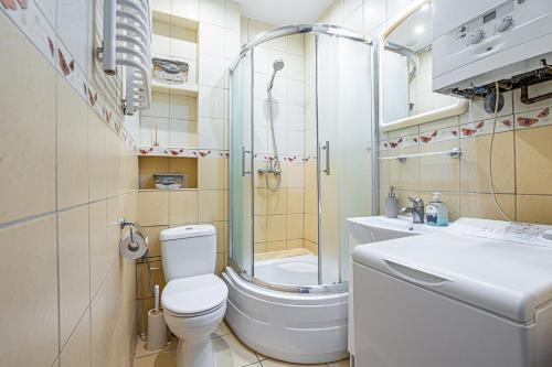 uma casa de banho com um WC, um chuveiro e um lavatório. em Apartament Gdynia em Gdynia