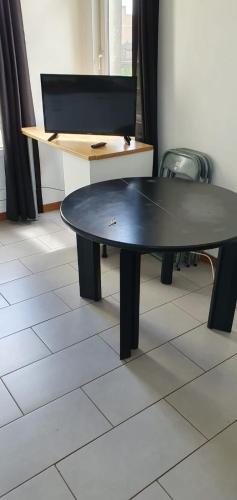 uma mesa de pingue-pongue num quarto com uma secretária em f2 avec terasse sud ouest em Dunkerque