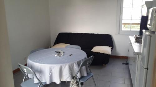 uma cozinha com uma mesa e um sofá num quarto em f2 avec terasse sud ouest em Dunkerque