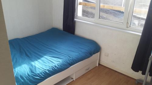 uma pequena cama num quarto com uma janela em f2 avec terasse sud ouest em Dunkerque