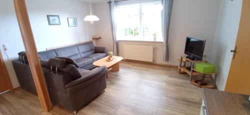 a living room with a couch and a television at Ferienwohnung Kröger in Rhede