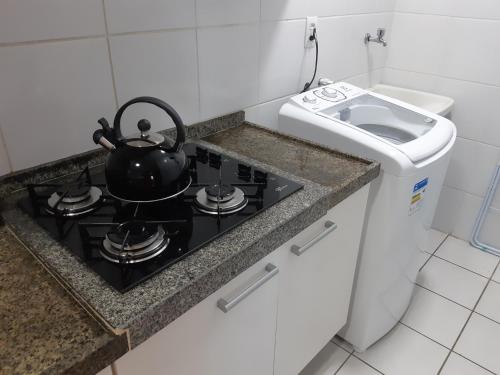 uma chaleira de chá num fogão na cozinha em Apartamento acolhedor próximo ao mar da Jatiúca. em Maceió