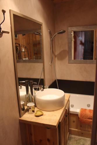 a bathroom with a sink and a mirror and a tub at Praloup 1600 beau studio avec très belle vue in Pra-Loup