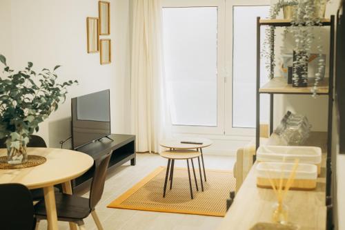 a living room with a table and chairs and a tv at Club Apartments by Grupo Compostelana 1 in Puerto de la Cruz