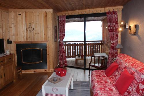 un salon avec un canapé et une cheminée dans l'établissement Praloup 1600 beau studio avec très belle vue, à Pra-Loup