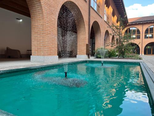 a swimming pool in front of a brick building at Corte Milano in Rozzano