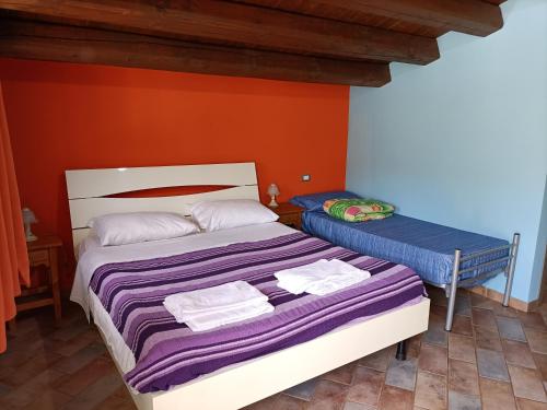 a bedroom with a bed and a table with towels on it at Casolare La Torre in Scopello
