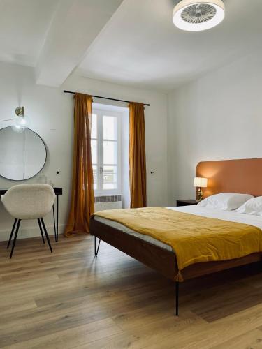 a bedroom with a bed and a desk and a chair at Superbe appartement T2 en plein centre d'Ajaccio, rue Fesch in Ajaccio