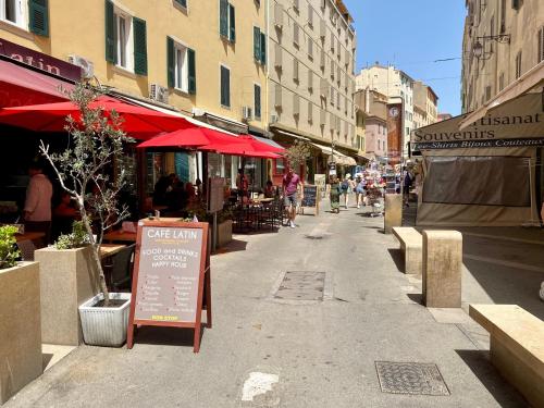 a street with a restaurant and a sign on the sidewalk at Superbe appartement T2 en plein centre d'Ajaccio, rue Fesch in Ajaccio