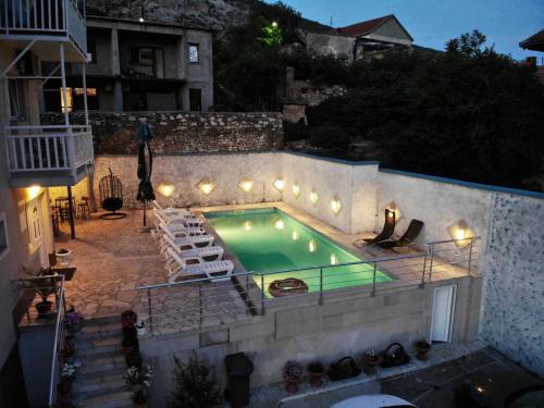 een zwembad met ligstoelen naast een gebouw bij Villa Horizont Mostar in Mostar