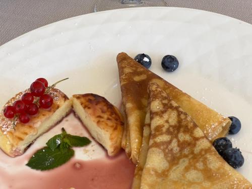 a plate of food with bread and fruit on it at Hotel Millenium deluxe in Selce