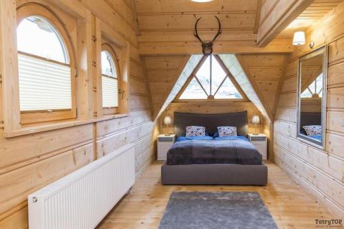 1 dormitorio con 1 cama en una casa de madera en TatryTop Jelenia Chata en Kościelisko