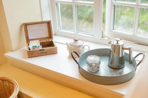 a window sill with a tray with a tea kettle and a box at Fox And Hounds Llancarfan in Barry