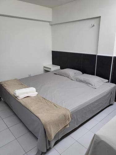 a bedroom with a large bed in a white room at Lindo Flat no Royal Residence Flat in João Pessoa