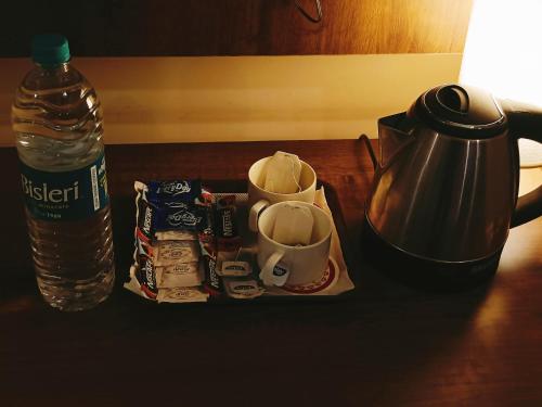 a table with a coffee pot and a bottle of water at Mayda Inn- A Boutique Hotel in New Delhi
