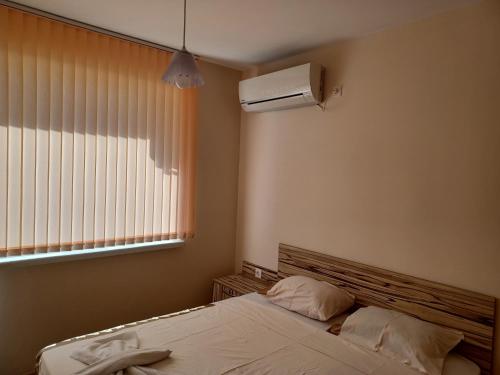 a bedroom with a bed and a air conditioner at Апартамент Желева in Pomorie