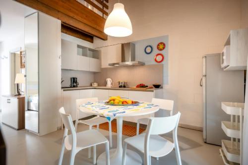 a kitchen and dining room with a table and chairs at Residence Duna Rossa - Family Friendly in Duna Verde
