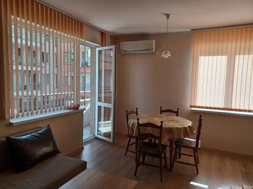 a living room with a table and chairs and a couch at Апартамент Желева in Pomorie