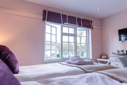a bedroom with a bed and a large window at Fox And Hounds Llancarfan in Barry