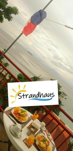 a table with plates of food on top of a balcony at Strandhaus Condotel in Moalboal