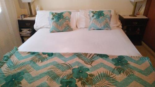 a bed with a comforter and pillows on it at Anandi planta alta in San Nicolás de los Arroyos
