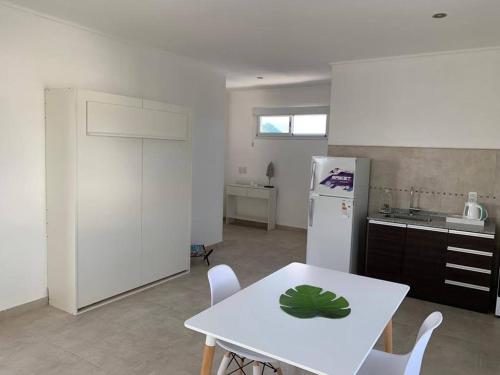 a kitchen with a white table and a white refrigerator at Anandi planta alta in San Nicolás de los Arroyos