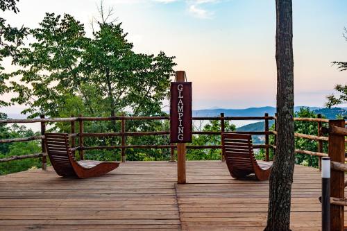 a sign on a wooden deck with two chairs at AgriResort Spa Glamping Poggio Di Montedoro in Montefiascone