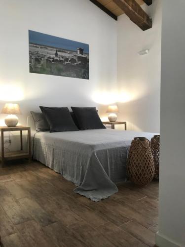 a white bedroom with a bed and two lamps at THE RANCH Apartment 2 Capalbio in Pescia Romana