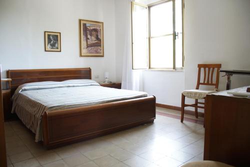 1 dormitorio con cama, ventana y silla en Casa Nina, Sardegna sud ovest, Bacu Abis 6 minuti dal mare, en Bacu Abis
