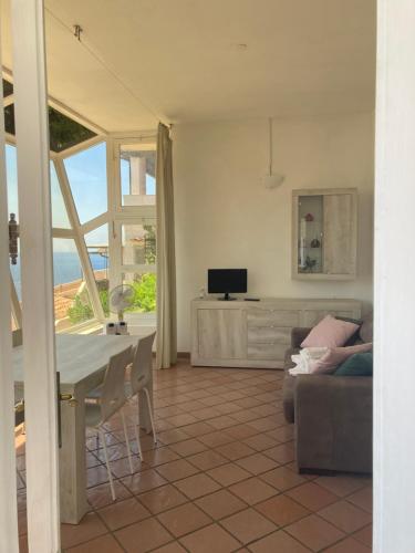 a living room with a table and a couch at Vetrata sul mare in Campese
