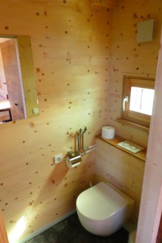 drewniana łazienka z toaletą i oknem w obiekcie Garnecker Freiheit w mieście Reut