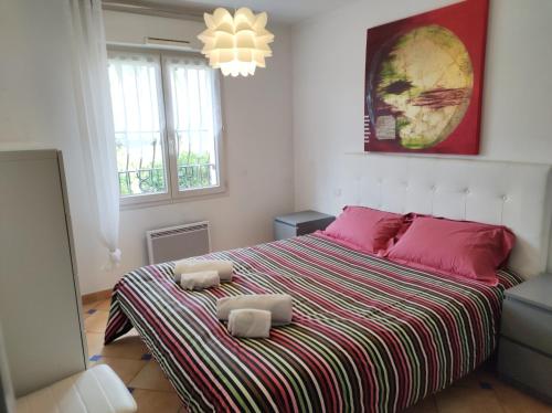 a bedroom with a large bed with pink pillows at Port marine appartement 3 pièces avec piscine in Sainte-Maxime