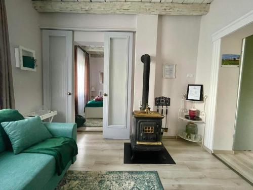 a living room with a green couch and a wood stove at Smaragd in Doba