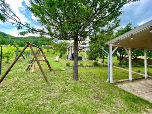 a swing set in a yard with a tree at Smaragd in Doba