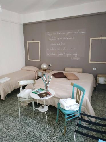 a bedroom with two beds and a chalkboard on the wall at Le Dimore degli Artisti in Venosa