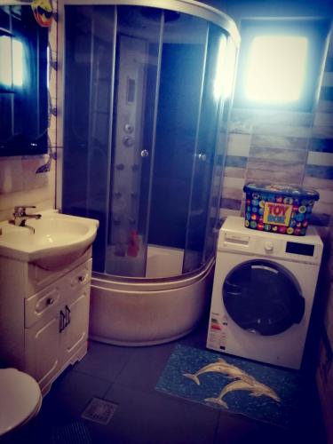 a bathroom with a shower and a washing machine at apartament eforie nord in Eforie Nord