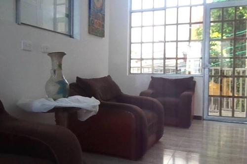 a living room with two chairs and a vase on a table at Villa Aurora in Ricaurte